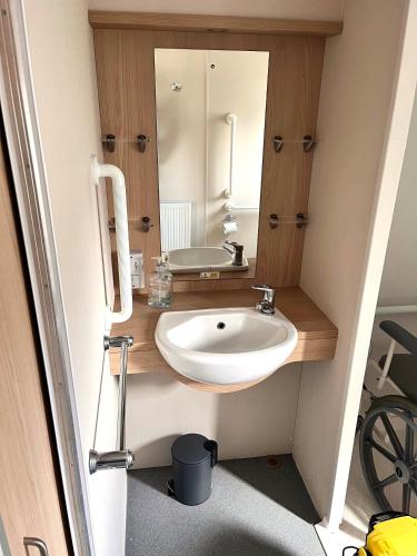 a bathroom with a sink and a mirror at Thames view at Kent Coast Holiday Park in Allhallows