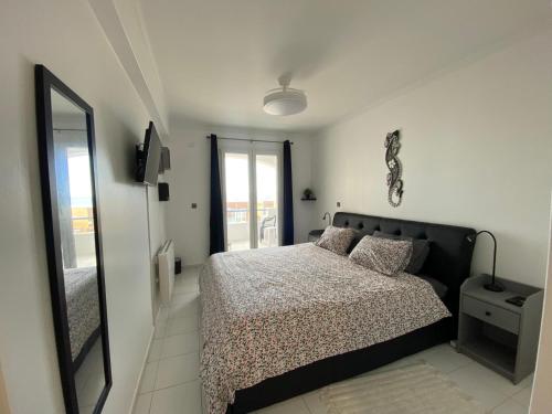 a bedroom with a bed and a large mirror at Apartamento na Praia in Vieira de Leiria