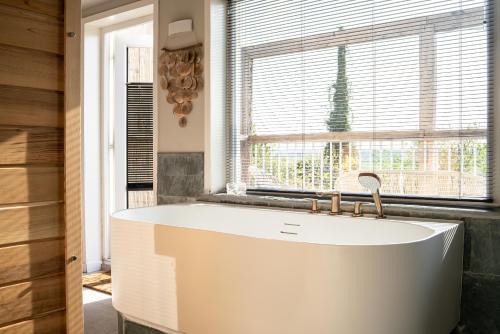 a white sink in a bathroom with a window at Maas Suites (Maastricht - Lanaken) in Lanaken