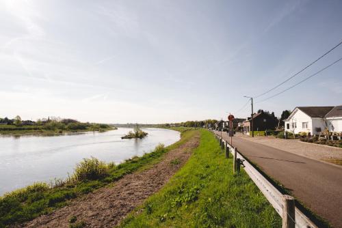 a road next to a river next to a street at Maas Suites (Maastricht - Lanaken) in Lanaken