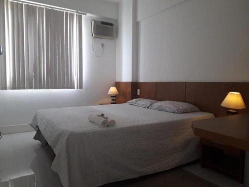 een slaapkamer met een bed met twee handdoeken erop bij Hotel Via Park- NF e Wi-Fi in Campos dos Goytacazes