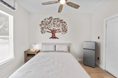 a bedroom with a bed with a tree on the wall at Charming Private Hotel Room Perfect for Couples Near East Austin in Austin