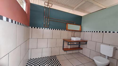 a bathroom with a toilet and a mirror at ZuriCamp - Campsite Safiri in Tsumeb