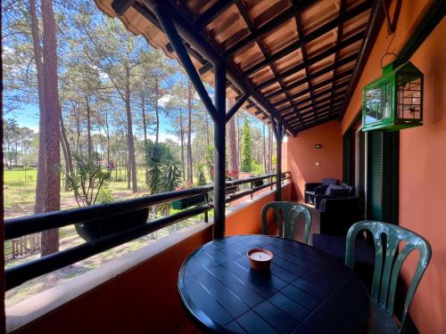 a table and chairs in a room with a window at Golf and Beach Serenity in Aroeira