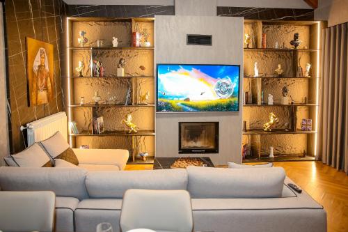 a living room with a couch and a tv at N'Gen Luxury Villas - Razem in Razëm
