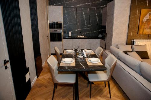 a dining room with a table and chairs and a couch at N'Gen Luxury Villas - Razem in Razëm
