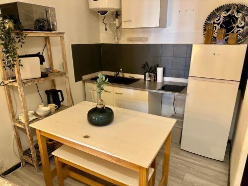 une petite cuisine avec une table et un réfrigérateur dans l'établissement Studio Rdc proche Quai Rouget, à LʼIsle-sur-la-Sorgue
