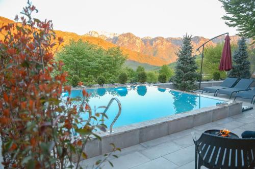 a large swimming pool with mountains in the background at N'Gen Luxury Villas - Razem in Razëm