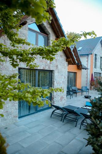 a patio with picnic tables and chairs in front of a building at N'Gen Luxury Villas - Razem in Razëm