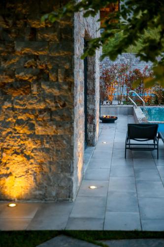 a bench sitting on a patio next to a stone wall at N'Gen Luxury Villas - Razem in Razëm