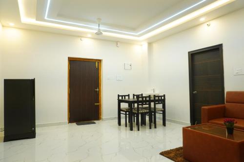 een woonkamer met een tafel en stoelen bij BHARATHI STAYS Ultra luxury rooms 1RK Studio Apartments & 2BHK Apartments in Tirupati