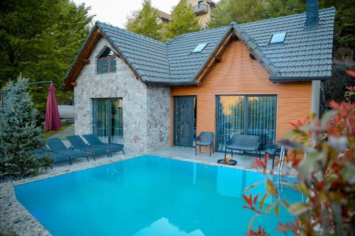 a swimming pool in front of a house at N'Gen Luxury Villas - Razem in Razëm