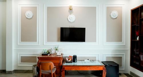 a room with a desk and a tv on a wall at Lucasta Hotel in Can Tho