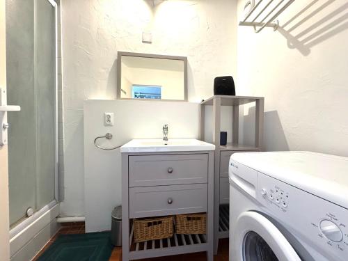 a bathroom with a sink and a washing machine at Appartement spacieux 6 couchages in Cap d'Agde