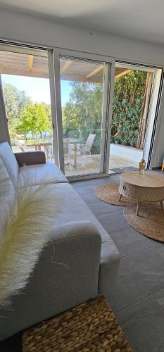 un salon avec un canapé et une table dans l'établissement Maison à 2 pas de la plage avec vue mer, à Lumio