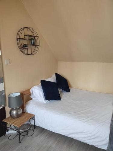 une chambre avec un lit avec deux oreillers et une table dans l'établissement L'essentiel - Appart. Charming in Tours, à Tours