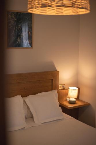 a bedroom with a bed and a nightstand with a lamp at Pensión O Camiño in Sarria
