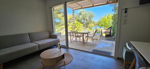 un salon avec un canapé et une table dans l'établissement Maison à 2 pas de la plage avec vue mer, à Lumio