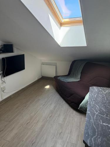 une chambre avec un lit et une télévision à écran plat dans l'établissement Mansarde à 1 min de la mer, à Nice