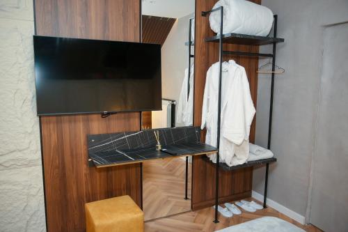 a room with a tv and a shelf with a television at N'Gen Luxury Villas - Razem in Razëm