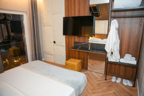 a hotel room with a bed and a television at N'Gen Luxury Villas - Razem in Razëm