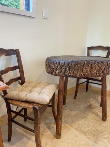 une table, deux chaises, une table et un tabouret dans l'établissement Chambre et bureau à deux pas d'Honfleur, à Fiquefleur-Équainville
