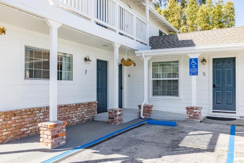 a white house with a blue door and a porch at Swell House Santa Cruz in Santa Cruz