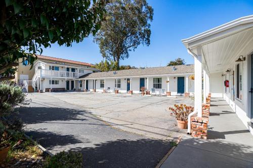 a row of white buildings with a driveway at Swell House Santa Cruz in Santa Cruz