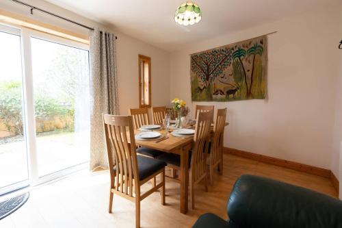 a dining room with a wooden table and chairs at Central Stay - Old Town Dingle in Dingle