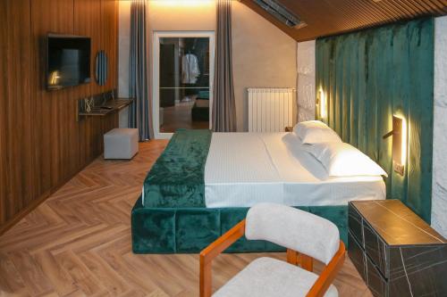 a bedroom with a bed and a tv and a couch at N'Gen Luxury Villas - Razem in Razëm