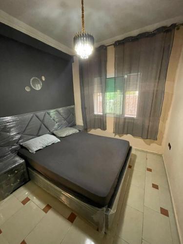 un grand lit dans une chambre avec une fenêtre dans l'établissement Appartement Tout Confort Ifrane, à Ifrane