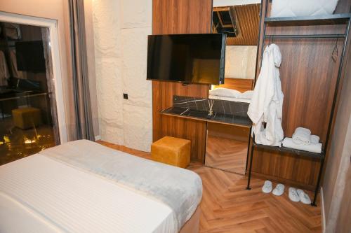 a hotel room with a bed and a television at N'Gen Luxury Villas - Razem in Razëm