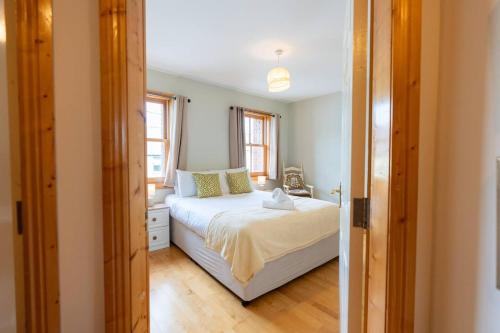 a bedroom with a white bed and a window at Central Stay - Old Town Dingle in Dingle