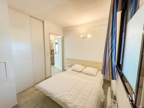 une petite chambre avec un lit dans une pièce dans l'établissement Spacieux T3 dans une résidence avec piscine, à Sanary-sur-Mer