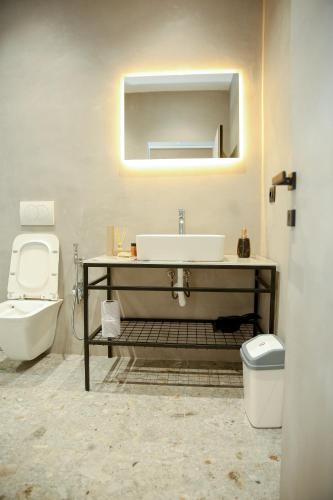 a bathroom with a sink and a toilet and a mirror at N'Gen Luxury Villas - Razem in Razëm