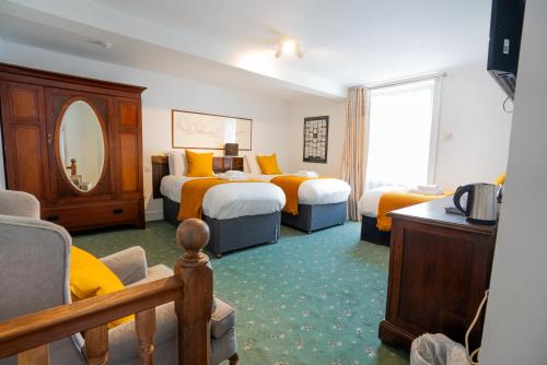 a hotel room with two beds and a mirror at Without A Paddle Hotel in Llangollen