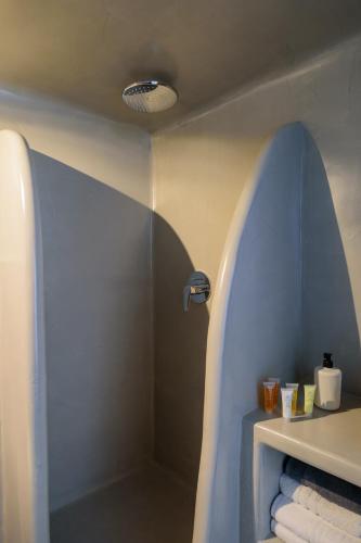a bathroom with a shower and some towels at Tataki Family Hotel in Fira