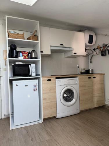 une cuisine avec un lave-linge et un lave-linge dans l'établissement Mansarde à 1 min de la mer, à Nice