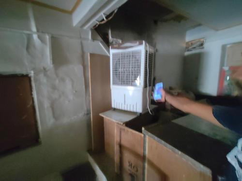 a person standing in a room with a microwave at ShreeJi Dham in Mathura