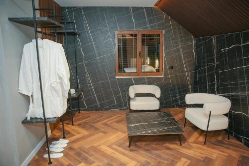 a bathroom with two white chairs and a mirror at N'Gen Luxury Villas - Razem in Razëm