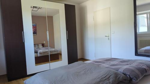 a bedroom with a bed and a large mirror at Elegant apartment with dream views in Pforzheim
