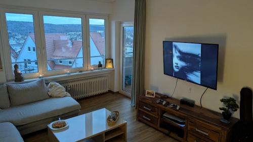 a living room with a couch and a flat screen tv at Elegant apartment with dream views in Pforzheim