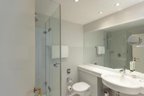a bathroom with a toilet and a sink and a shower at Best Western Plus Theodor Storm Hotel in Husum