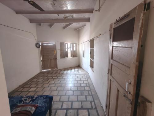 an empty room with a door and a tiled floor at ShreeJi Dham in Mathura