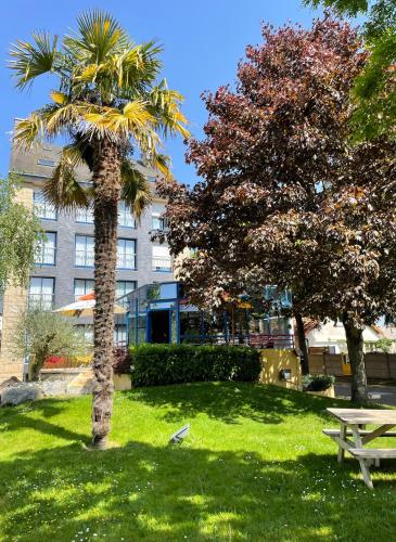 un palmier et une table de pique-nique dans un parc dans l'établissement Hotel Arcantis Le Voltaire, à Rennes