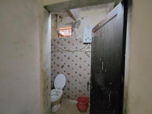 a small bathroom with a toilet and a window at ShreeJi Dham in Mathura