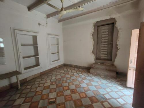 an empty room with a ceiling fan and windows at ShreeJi Dham in Mathura