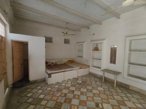 an empty room with a couch and a window at ShreeJi Dham in Mathura