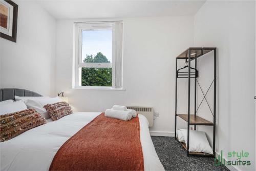 a white bedroom with a large bed and a window at Flat in Old Trafford Manchester in Manchester