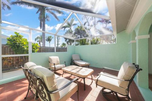 a room with chairs and a table and windows at Tipsy Turtle in Sanibel
